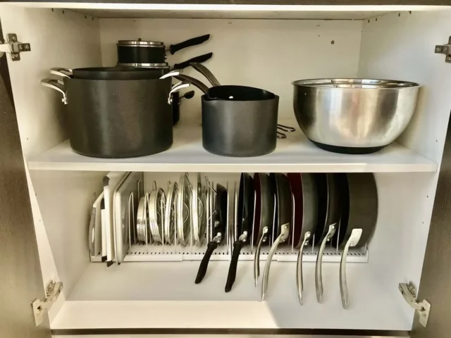 Kitchen cupboard showing neatly organzied set of pans and lids - After Picture